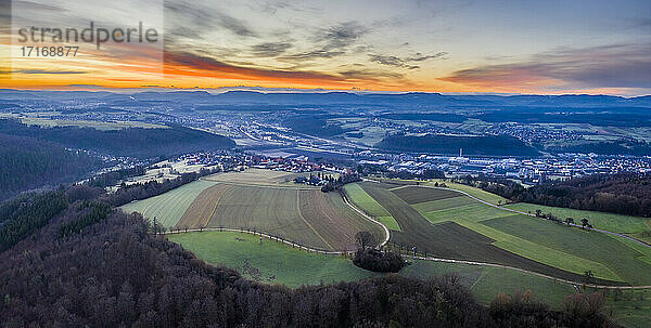 Landwirtschaftliches Feld vor dramatischem Himmel auf der Schwäbischen Alb bei Sonnenaufgang