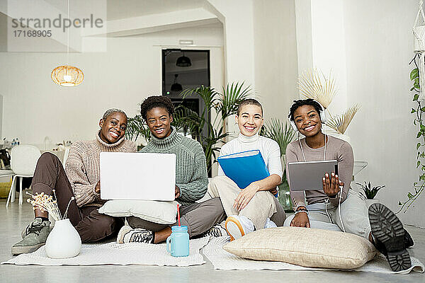 Happy female entrepreneurs working in living room