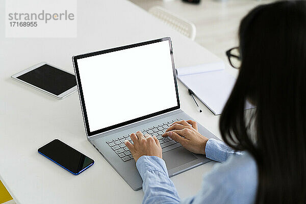 Geschäftsfrau mit Laptop bei der Arbeit im Büro