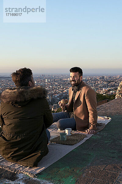 Schwules Paar im Gespräch beim Frühstück auf dem Aussichtspunkt  Bunkers del Carmel  Barcelona  Spanien