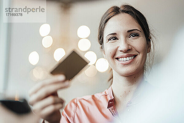 Lächelnde Geschäftsfrau mit Kreditkarte in einem Cafe