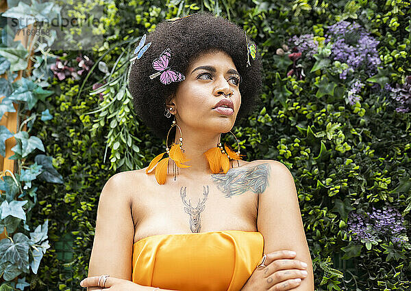 Afro woman looking away against plants