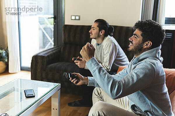 Fröhliche Freunde spielen ein Videospiel im heimischen Wohnzimmer