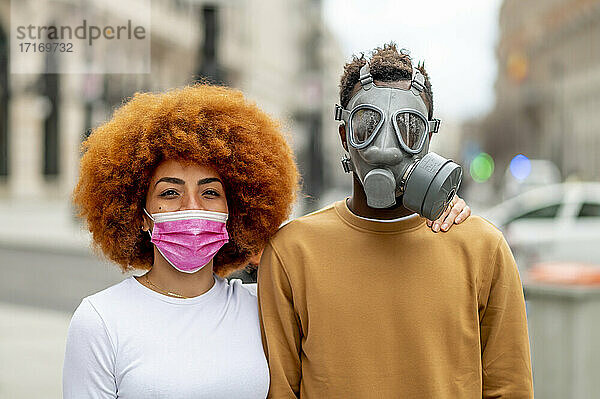 Couple wearing protective face mask staring while standing outdoors