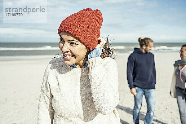 Porträt einer Frau mit gestricktem Hut am Strand