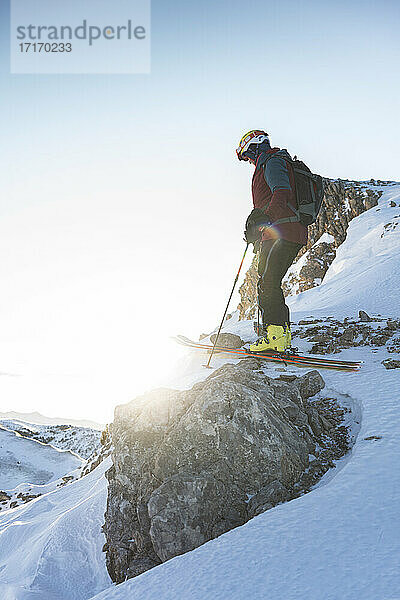 Male skier at mountain peak during sunrise