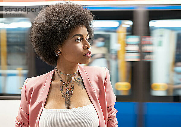 Afro woman looking away at subway station