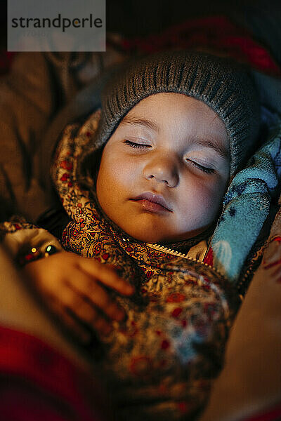 Baby-Mädchen mit Strickmütze beim Schlafen im Winter