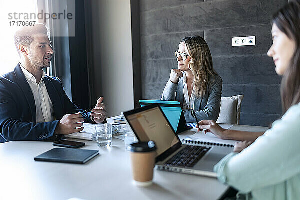 Business people having discussion while sitting in meeting at office