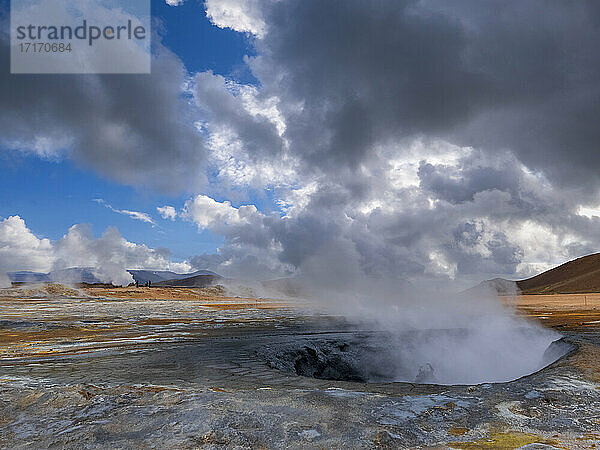 Steam emitting from geyser against cloudy sky  Hverir  Iceland
