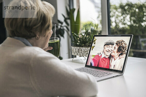 Ältere Frau bei einem Videogespräch mit Freunden über einen Laptop zu Hause