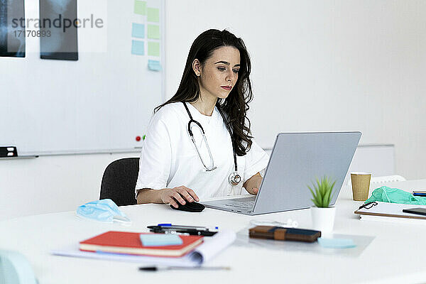 Ärztin berät online über Laptop in der Klinik