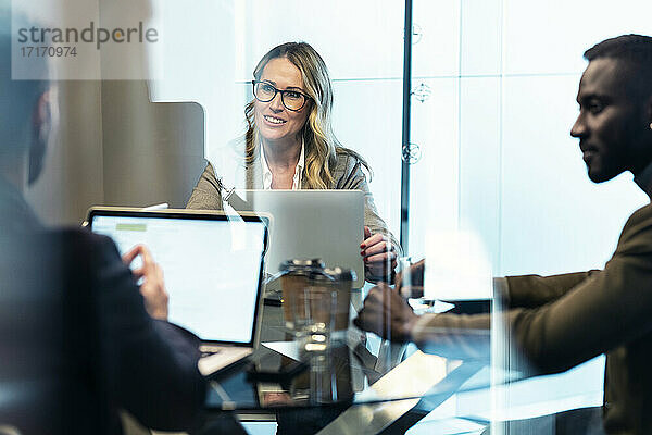 Businesswoman smiling while working with colleague in office