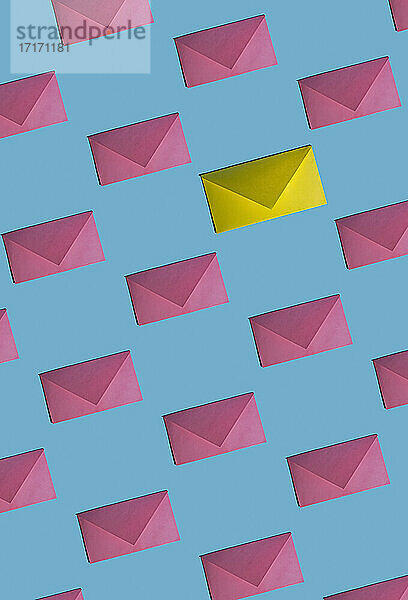 Muster aus Reihen von rosa Umschlägen mit einem einzigen gelben Umschlag