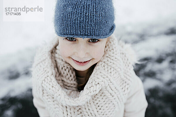 Glückliches kleines Mädchen in warmer Kleidung im Winter