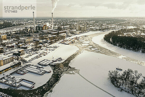 Germany  Berlin  Smoking power plant chimney towering over frozen Spree river