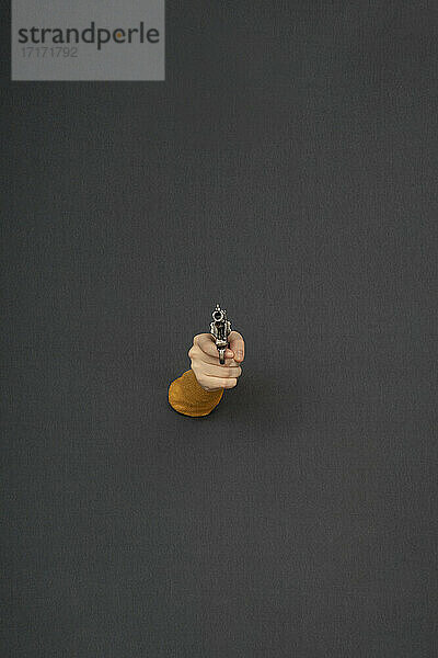 Studio shot of female hand holding old-fashioned revolver