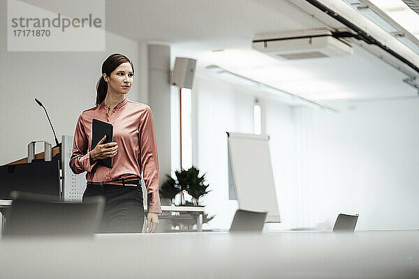 Unternehmerin mit digitalem Tablet im Sitzungssaal im Büro
