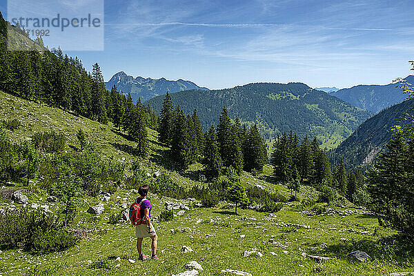 Mature hiker looking view while standing on Schellenberg-Alm mountain at Bavaria  Germany