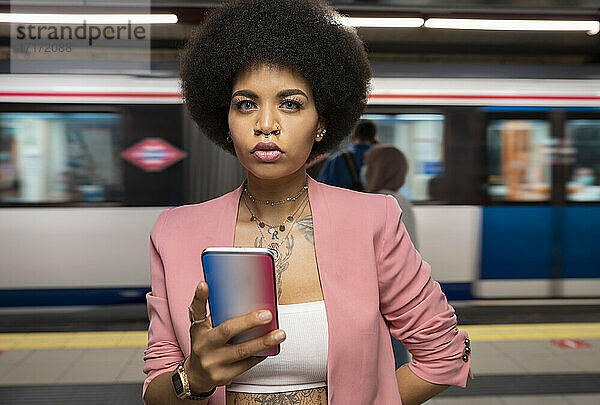 Young woman with smart phone at subway station