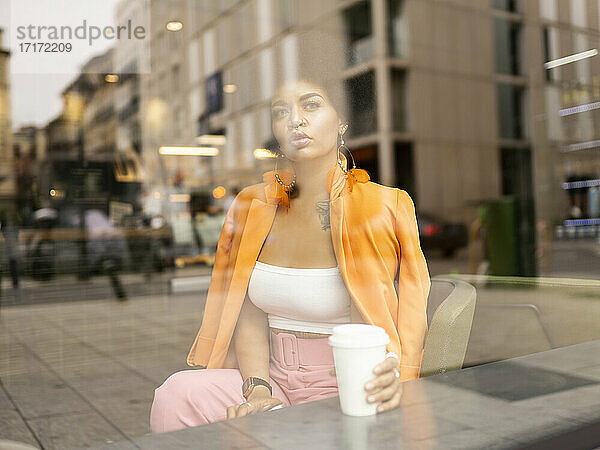 Young woman contemplating with coffee cup in cafe