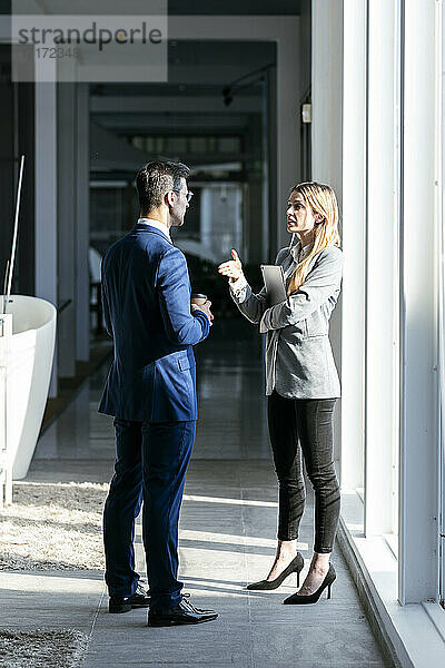 Geschäftsfrau streckt die Hand nach ihrem Partner aus  während sie im Büro steht