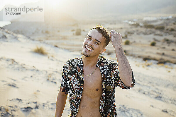 Glücklicher gut aussehender Mann mit aufgeknöpftem Hemd in der Wüste in Almeria  Tabernas  Spanien