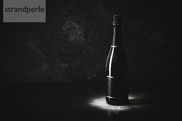 Studioaufnahme einer schwarzen Flasche Champagner mit leerem Etikett