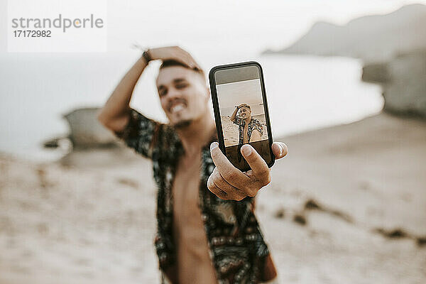 Junger Mann nimmt Selfie durch Smartphone in Almeria  Tabernas Wüste  Spanien