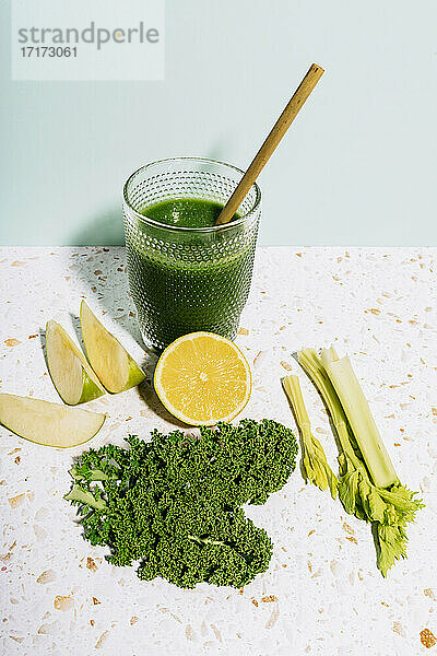 Healthy summer green juice with apple  lemon  kale and celery against wall