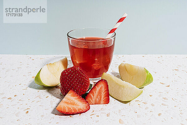 Healthy fruit juice with strawberry and apple on modern terrazzo marble against wall at home