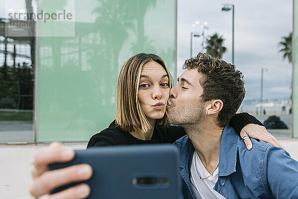Lächelndes Paar nimmt Selfie im Freien