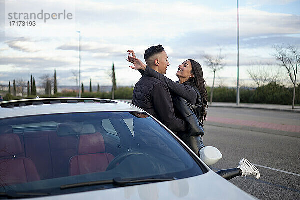 Junges Paar mit Arm um stehend durch Auto auf Straße