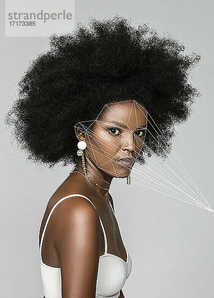 Afro woman with facial recognition laser beams against white background