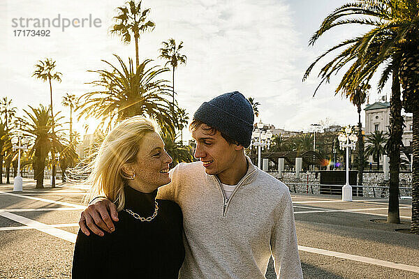 Smiling young couple at promenade during sunny day