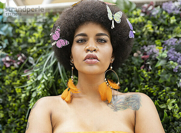 Female hipster with butterfly hair clip against plants