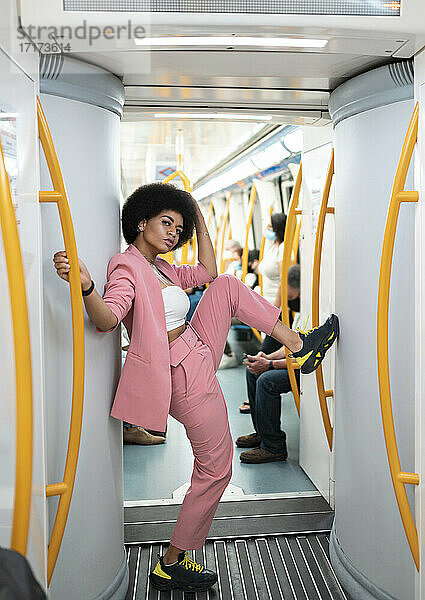 Female hipster with leg-up standing in train