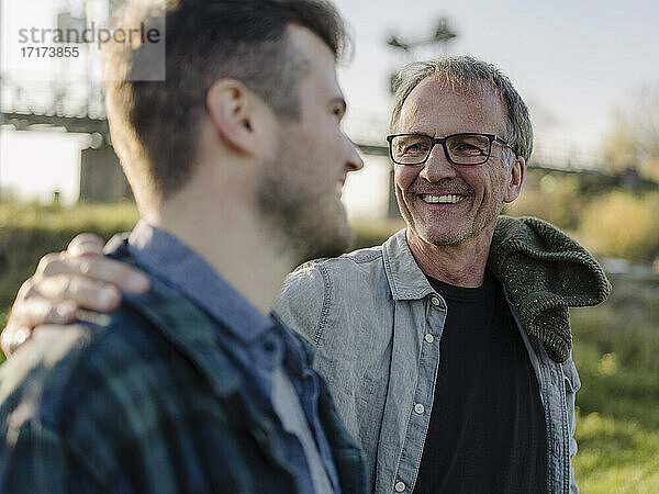 Smiling father talking with son outdoors