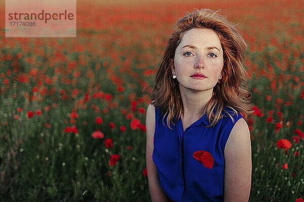 Beautiful woman standing in poppy field