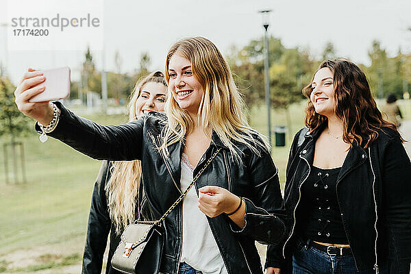 Freunde nehmen Selfie auf Telefon im Freien