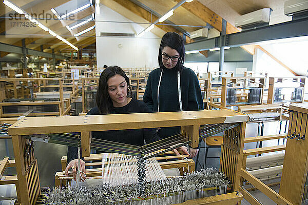Studenten beim Weben am Webstuhl in der Textilwerkstatt