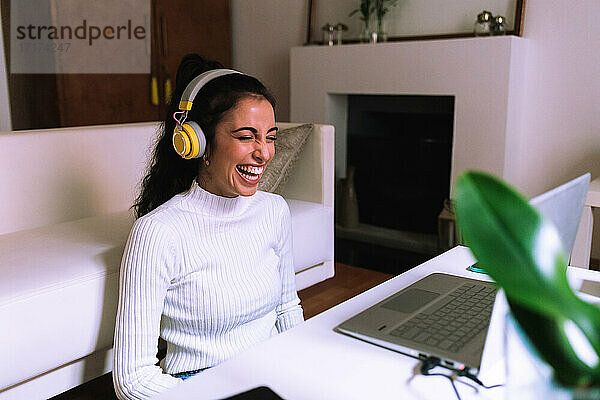 Junge Frau bei Videogespräch am Laptop  lachend