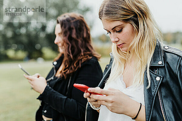 Zwei junge Frauen schauen auf ihre Telefone