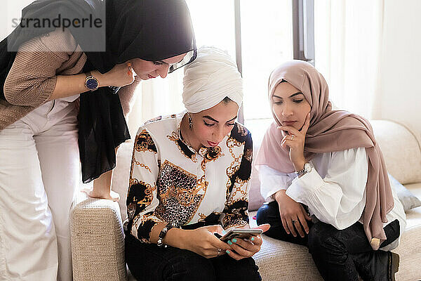 Weibliche Freunde schauen auf ihr Smartphone