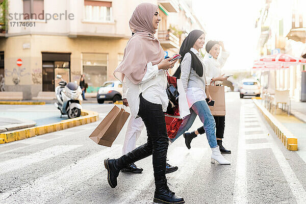 Junge Frauen auf Einkaufstour  die Straße überqueren