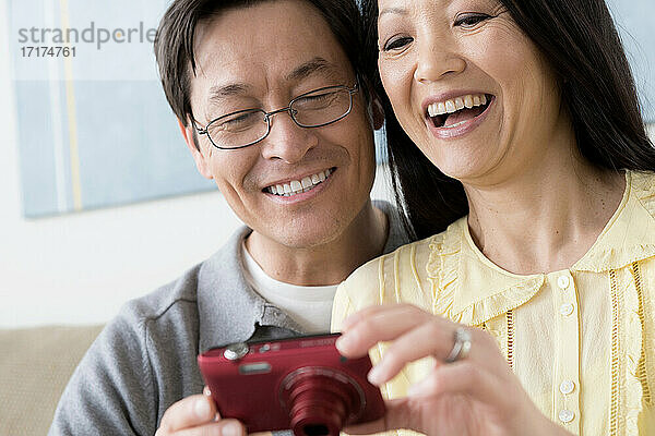 Älteres Paar schaut auf Digitalkamera
