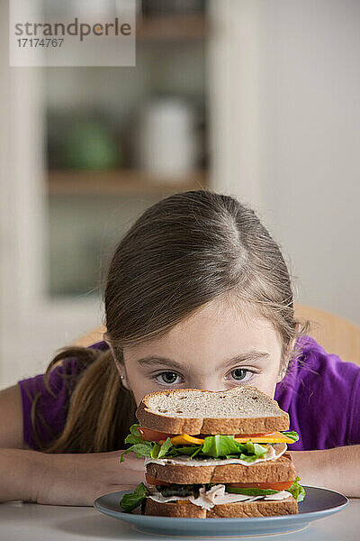 Mädchen starrt auf Sandwich