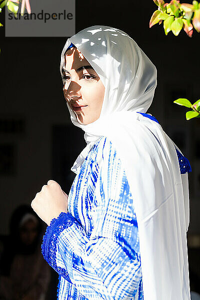 Porträt einer jungen Frau mit Hidschab im Sonnenlicht und im Schatten