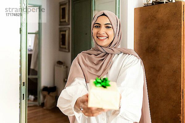 Junge muslimische Frau gibt ein Geschenk