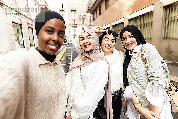 Vier junge Frauen tragen Hidschab und machen ein Selfie